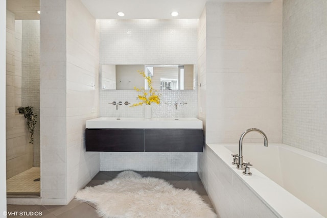 bathroom featuring tile walls, vanity, tile patterned floors, and independent shower and bath