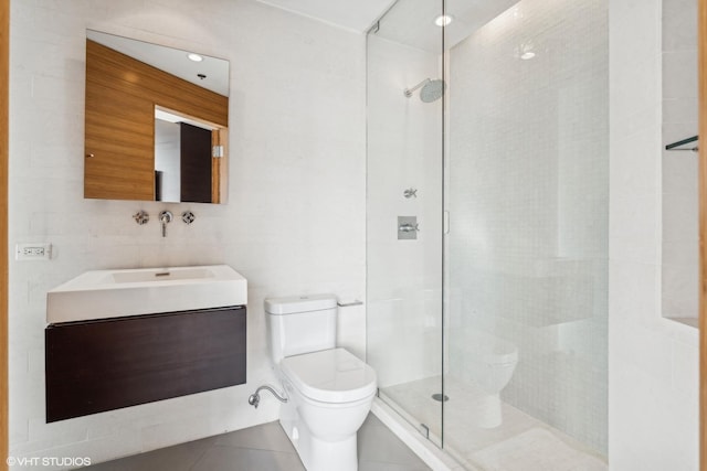 bathroom featuring vanity, tiled shower, and toilet