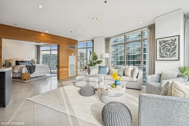 tiled living room featuring wooden walls and expansive windows