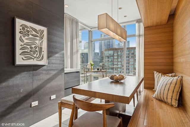 dining room with a wall of windows and light hardwood / wood-style flooring