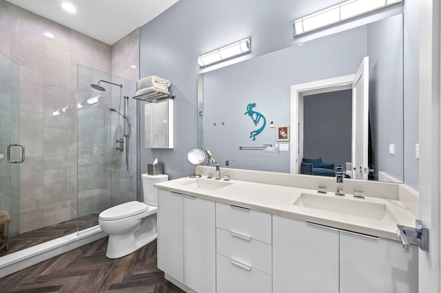 bathroom featuring vanity, parquet flooring, a shower with door, and toilet