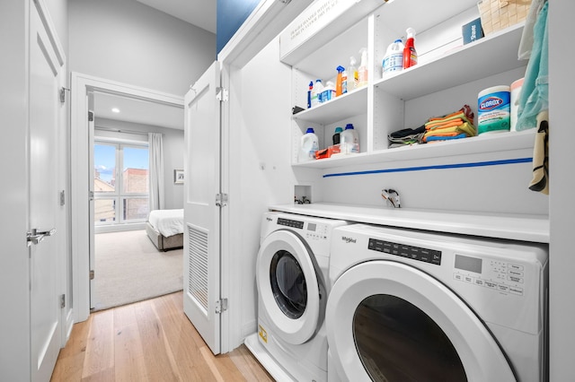 laundry area featuring light hardwood / wood-style floors and washing machine and clothes dryer