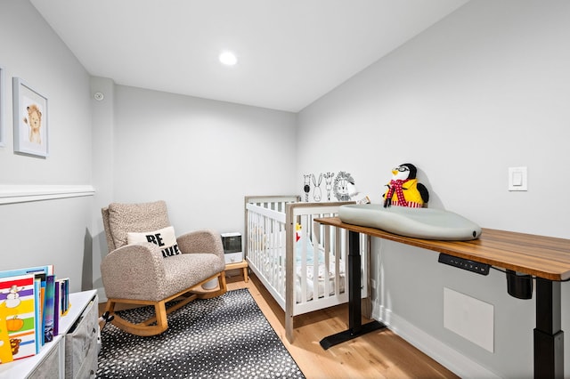 bedroom featuring a crib and light hardwood / wood-style floors