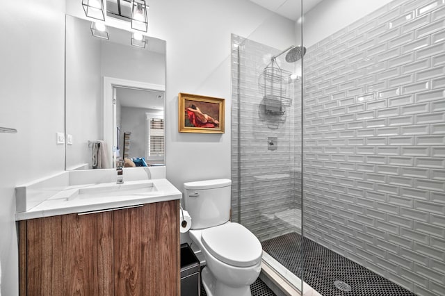 bathroom with vanity, toilet, and tiled shower