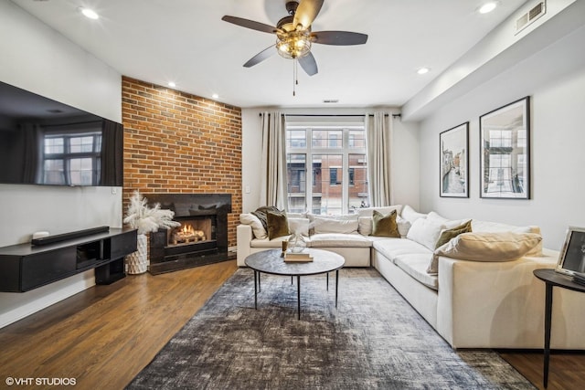 living room with ceiling fan, dark hardwood / wood-style floors, and a fireplace