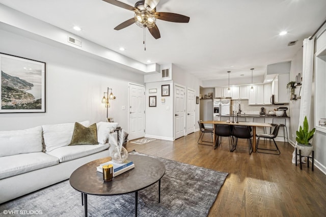 living room with dark hardwood / wood-style flooring and ceiling fan