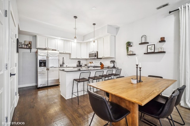 dining room featuring sink and dark hardwood / wood-style flooring