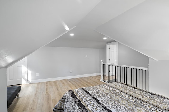 unfurnished bedroom featuring lofted ceiling and light wood-type flooring