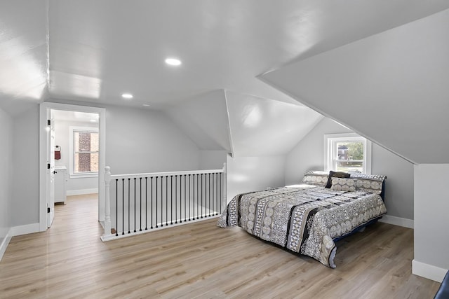 bedroom with multiple windows, light hardwood / wood-style flooring, and vaulted ceiling