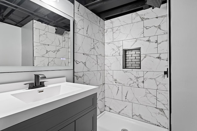 bathroom with vanity and a tile shower