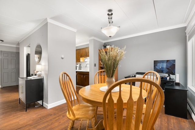 dining room featuring dark wood-type flooring, crown molding, and sink