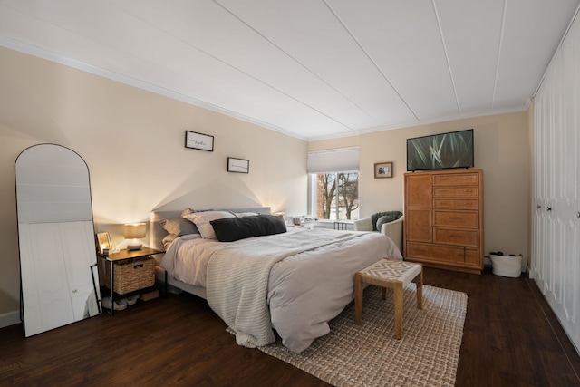 bedroom featuring ornamental molding and dark wood-type flooring