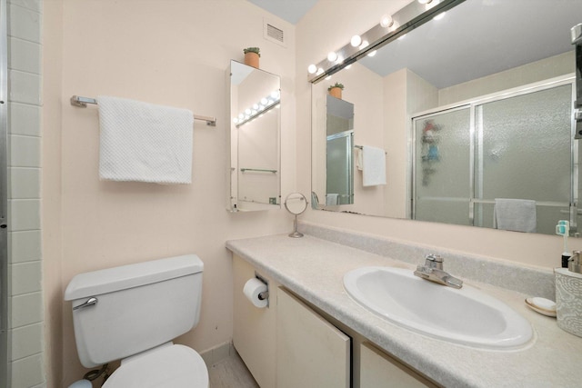 bathroom with vanity, toilet, and an enclosed shower