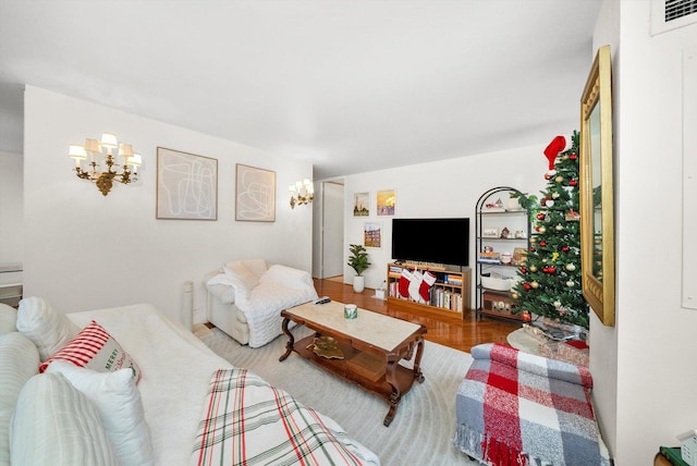 living room featuring an inviting chandelier and wood-type flooring