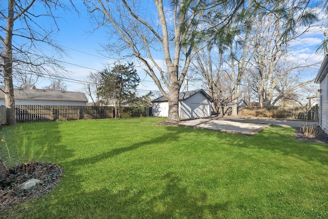 view of yard featuring a garage, an outdoor structure, and a patio