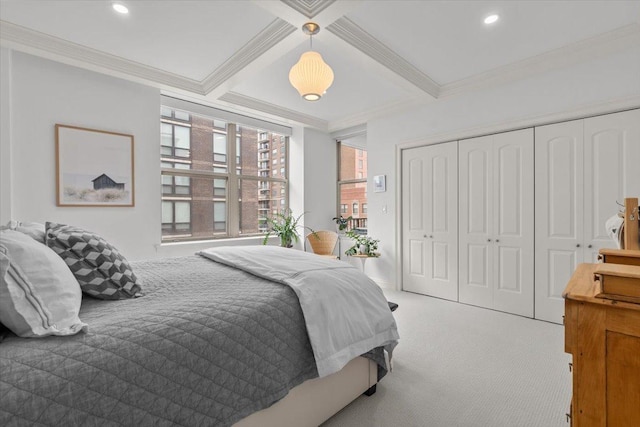 carpeted bedroom with beamed ceiling, ornamental molding, and a closet