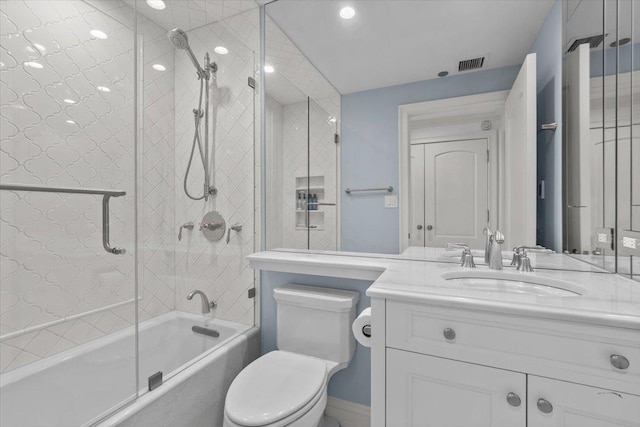 full bathroom featuring bath / shower combo with glass door, vanity, and toilet