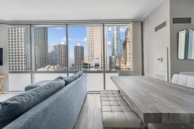 bedroom with multiple windows, floor to ceiling windows, and light hardwood / wood-style flooring