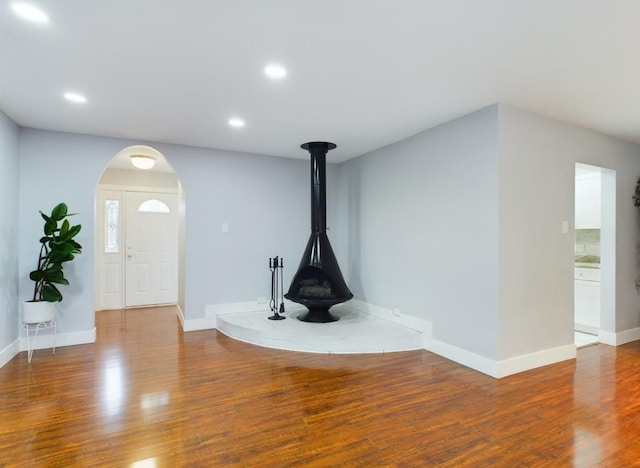 unfurnished living room with hardwood / wood-style floors and a wood stove