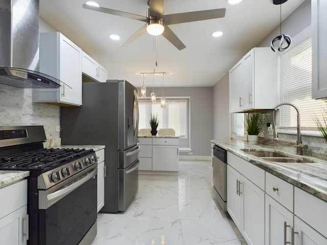 kitchen with sink, white cabinetry, stainless steel appliances, light stone countertops, and wall chimney exhaust hood