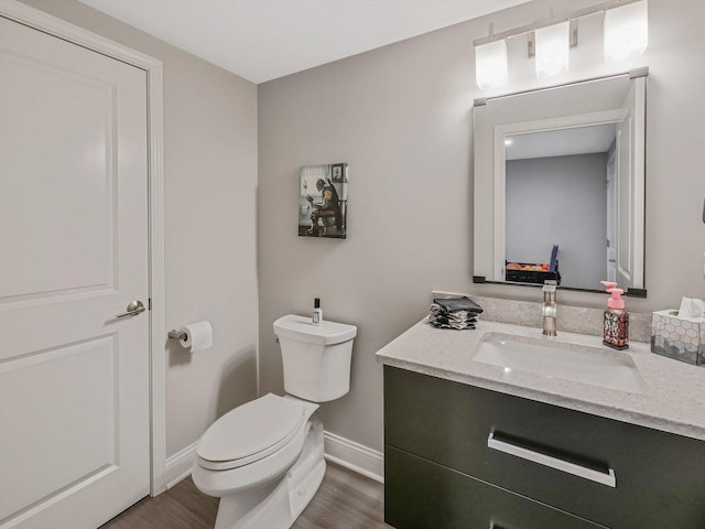 bathroom with hardwood / wood-style flooring, vanity, and toilet