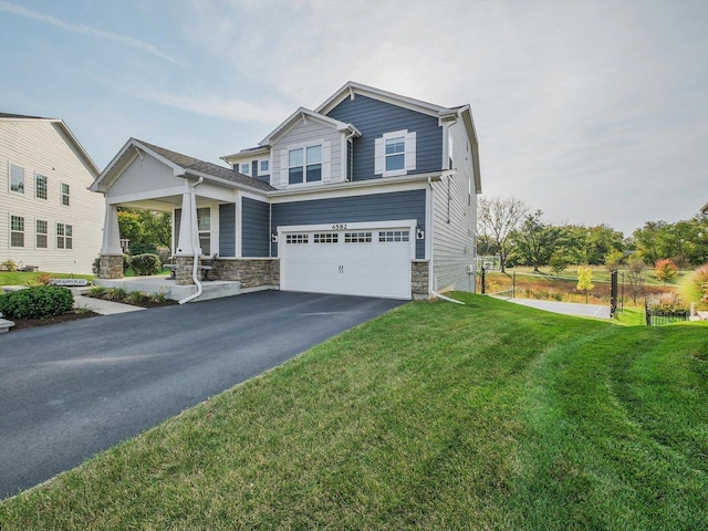 craftsman inspired home with a garage, a front lawn, and covered porch