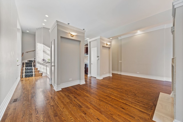 unfurnished living room with crown molding and wood-type flooring