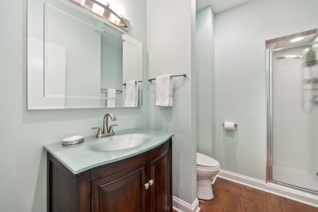 bathroom featuring wood-type flooring, toilet, an enclosed shower, and vanity