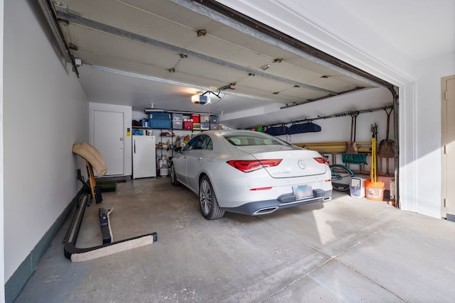 garage with a garage door opener and white fridge