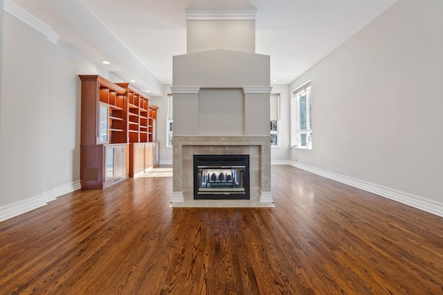 unfurnished living room featuring hardwood / wood-style flooring and a tiled fireplace