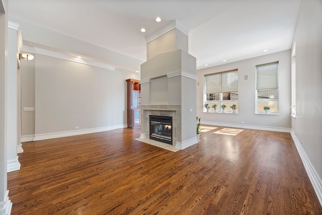 unfurnished living room featuring hardwood / wood-style flooring, ornamental molding, and a tile fireplace