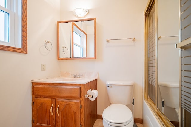 full bathroom featuring toilet, vanity, and bath / shower combo with glass door