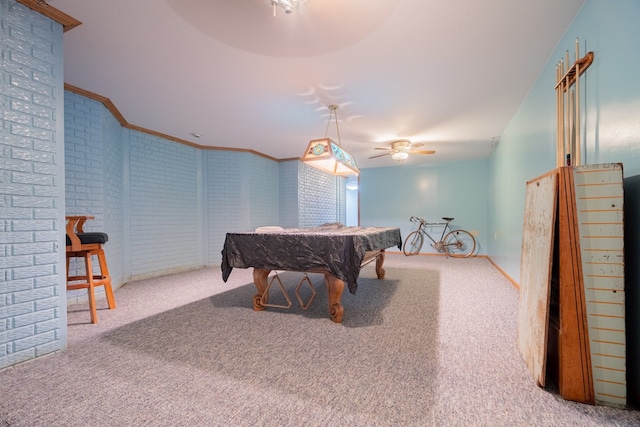 playroom with pool table, ornamental molding, carpet floors, ceiling fan, and brick wall