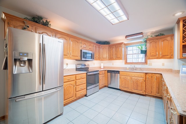 kitchen featuring stainless steel appliances, sink, and light tile patterned floors