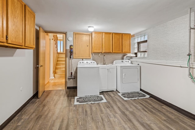 laundry room with cabinets, washer and dryer, and dark hardwood / wood-style flooring