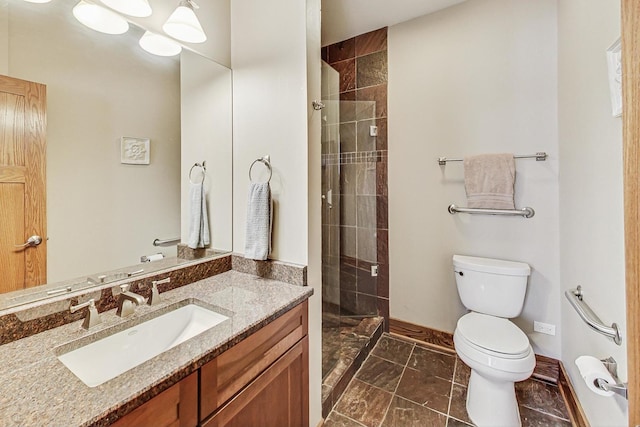 bathroom featuring vanity, a tile shower, and toilet