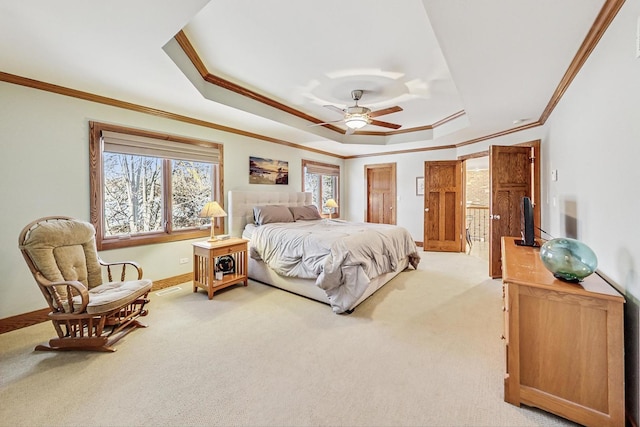 carpeted bedroom featuring a tray ceiling, ornamental molding, and ceiling fan