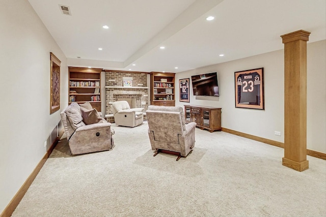 living room featuring light carpet, built in features, decorative columns, and a brick fireplace