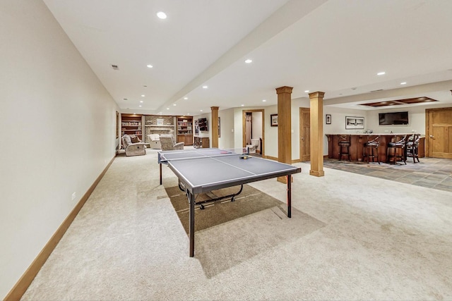 playroom featuring built in features, light colored carpet, decorative columns, and bar area