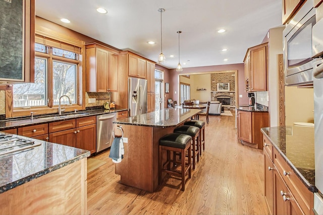 kitchen with pendant lighting, sink, a breakfast bar area, a center island, and stainless steel appliances