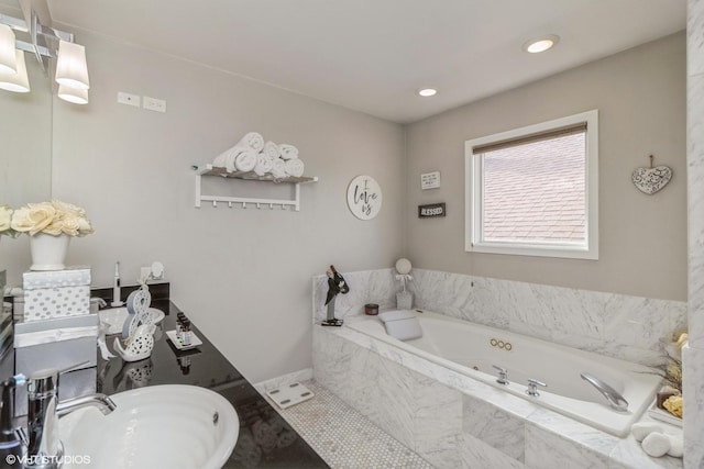 bathroom with a relaxing tiled tub, sink, and tile patterned flooring