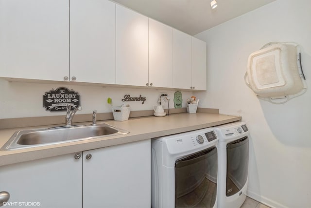 washroom with sink, washer and clothes dryer, and cabinets