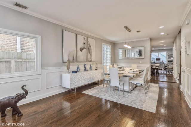 dining room with ornamental molding, dark hardwood / wood-style floors, and a chandelier