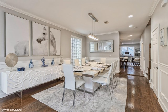 dining space featuring crown molding and dark wood-type flooring