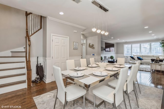 dining area featuring dark wood-type flooring and ornamental molding