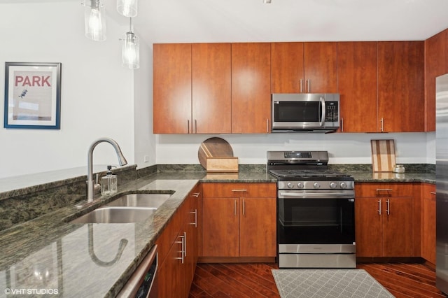 kitchen featuring stainless steel appliances, dark hardwood / wood-style floors, sink, and dark stone counters