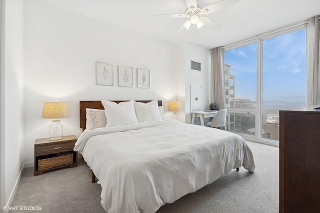 carpeted bedroom featuring multiple windows, ceiling fan, access to outside, and a wall of windows