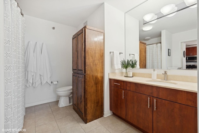 bathroom featuring tile patterned flooring, vanity, and toilet