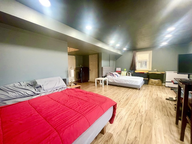 bedroom featuring washer / dryer and light hardwood / wood-style floors