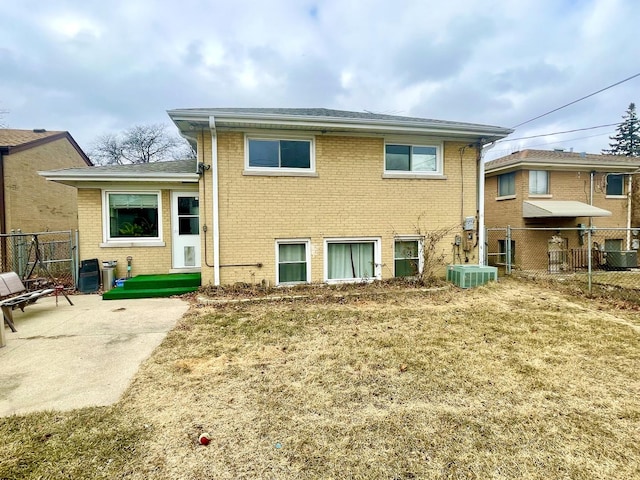 back of property with a yard, a patio, and central air condition unit